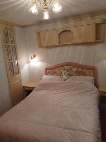 a teddy bear sitting on a bed in a bedroom at warden springs caravan park MS16 Thornhill road, Eastchurch,ME124HF in Sheerness