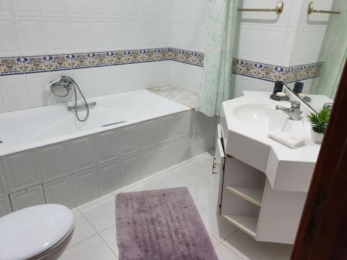 a bathroom with a tub and a sink and a toilet at La villa de la mer in Sidi Bou Jobline