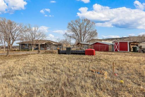 a field with a house and a red barn at Grand Canyon Ranch Home - Western History - Big city lot - AC! in Williams