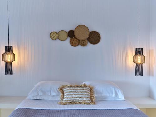 a bedroom with a bed with two lights and two hats at Ariti Seaside Residence in Naousa
