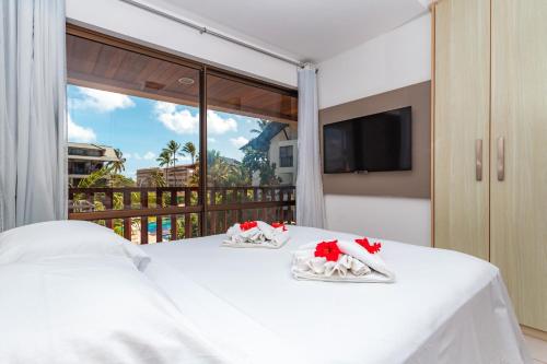 1 dormitorio con cama blanca y balcón en Nannai Residence by AFT, en Porto de Galinhas