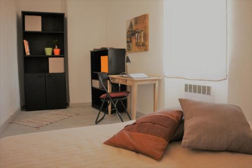 Ce lit se trouve dans un dortoir doté d'un bureau et d'une chaise. dans l'établissement Casamano, à Elne