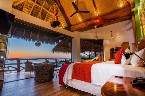 a bedroom with a bed and a view of the ocean at Villa Lala Boutique Hotel Adults Only in Puerto Vallarta