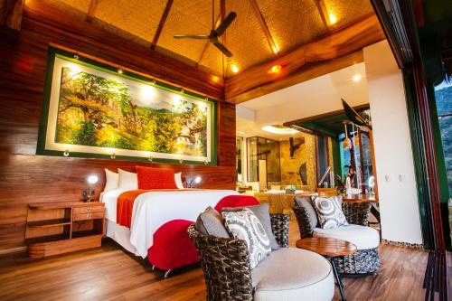 a bedroom with a bed and two chairs at Villa Lala Boutique Hotel Adults Only in Puerto Vallarta