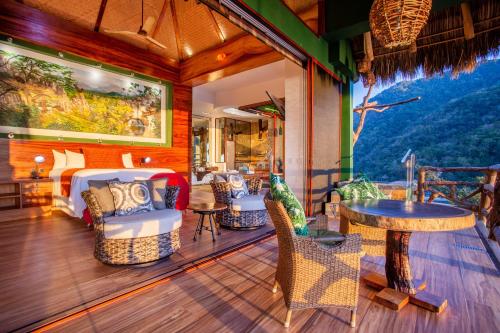 a room with chairs and a bed and a table at Villa Lala Boutique Hotel Adults Only in Puerto Vallarta