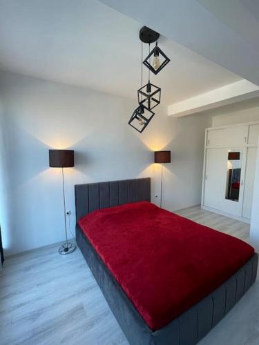 a bedroom with a large red bed with two lamps at Penthouse with castle view in Prizren