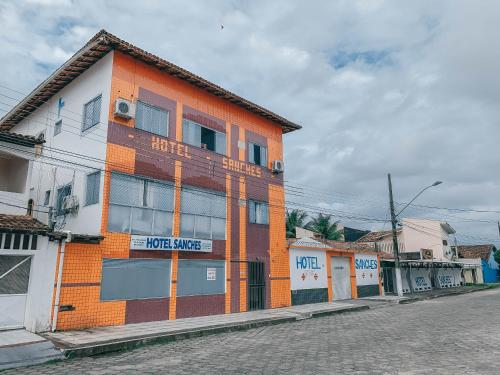 an orange building on the side of a street at Hotel Sanches in São Mateus