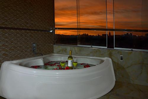 Terramística Arequipa - Monasterio في أريكيبا: حوض استحمام مع زجاجة من النبيذ وكأسين
