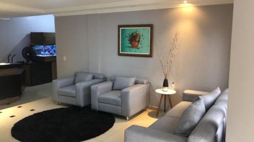 un soggiorno con 2 divani e un tappeto di Acalantus Hotel a Goiânia