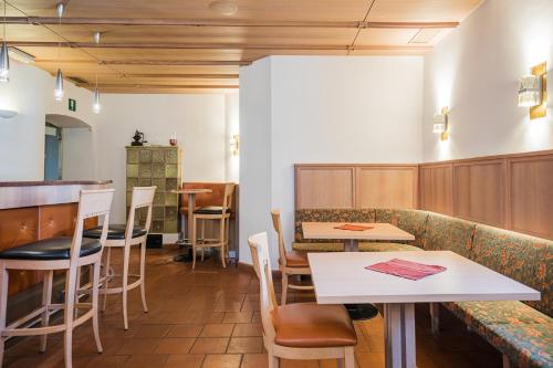 a restaurant with tables and chairs and a counter at Hotel Kronplatz in Valdaora