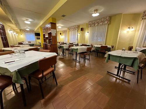 ein Restaurant mit Tischen und Stühlen sowie weißen Tischdecken in der Unterkunft HOSTAL EL CHOCOLATERO in Castildelgado