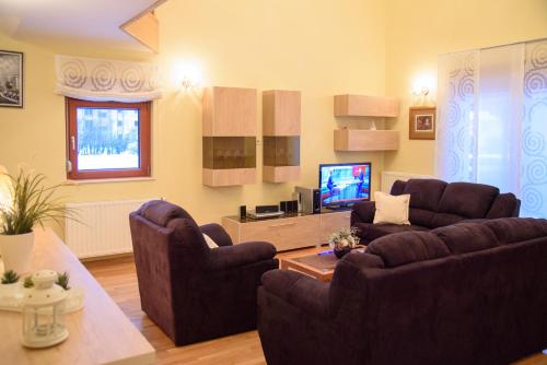 a living room with two couches and a tv at Villa Bjelolasica in Jasenak