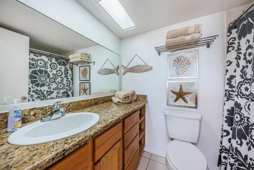 a bathroom with a sink and a toilet and a mirror at Sandcastle North Unit #403 in Clearwater Beach