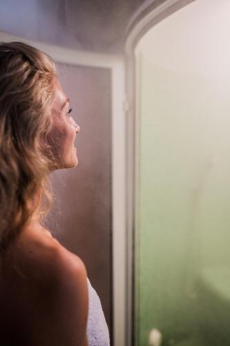a woman looking at her reflection in a mirror at Hotel Kronplatz in Valdaora