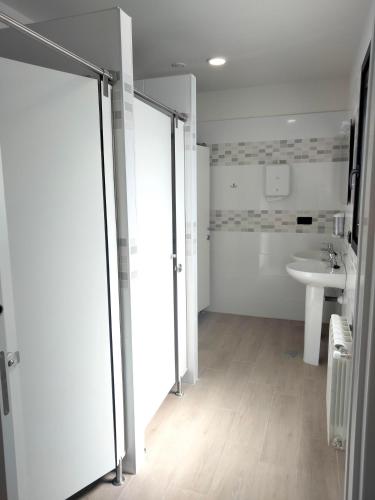 a bathroom with a shower and a sink and a toilet at Albergue turístico Anam Cara House in Serantes