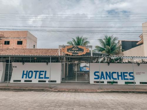a hotel with signs on the side of a building at Hotel Sanches in São Mateus