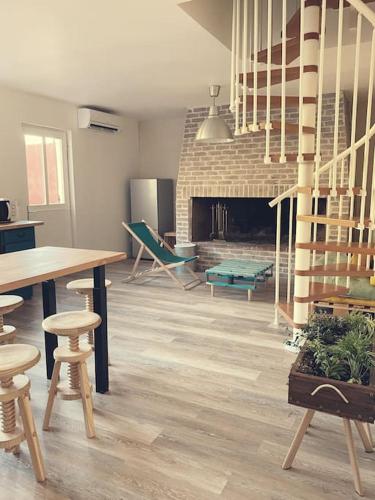 un salon avec une table et des chaises et une cheminée dans l'établissement Maison de campagne dans un domaine viticole, à Tautavel