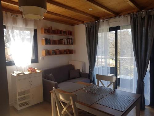 ein Wohnzimmer mit einem Tisch und einem Sofa in der Unterkunft Gîte Le Logis Vallat haut in Fuveau