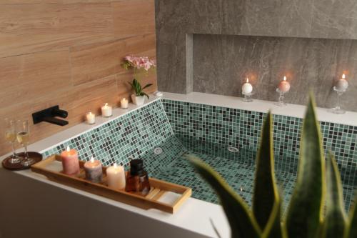 bagno con vasca e candele di Palmetto Hotel Business San Miguel a Lima