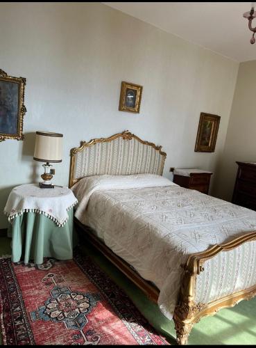 um quarto com uma cama e uma mesa com um candeeiro em Residenza Le Magnolie em Verbania