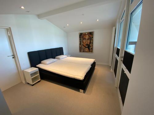 um quarto com uma cama e um quadro na parede em Strandhuset. em Asperup
