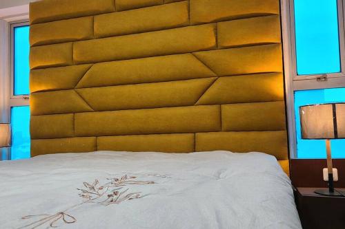- une chambre avec un grand lit et une grande tête de lit dans l'établissement Luxurious Studios, à Douala