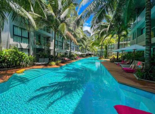 a swimming pool at a resort with palm trees at Diamond Resort Phuket Bangtao in Phuket