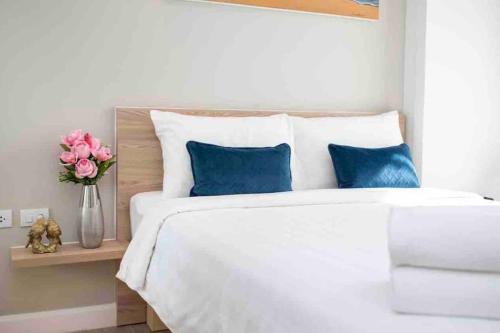 a bedroom with a white bed with blue pillows at Diamond Apartments Phuket Bangtao in Phuket Town