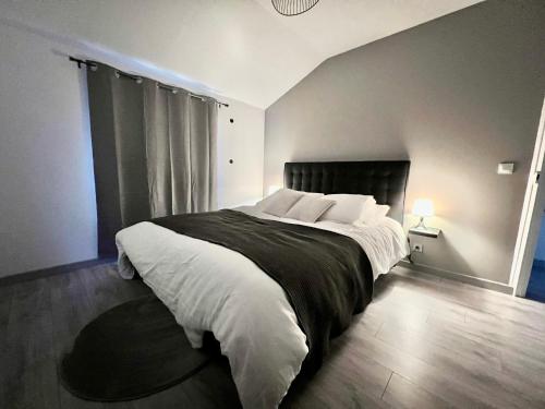 1 dormitorio con 1 cama grande con almohadas blancas en Appartement chaleureux proche RER/ CDG / Parc Expo en Sevran