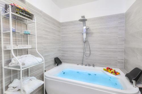 a bathroom with a tub with a shower at צימר נוף להר in Shelomi