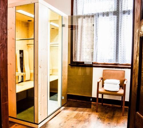a room with a mirror and a chair and a window at Apartment Chalet Kladska in Mariánské Lázně