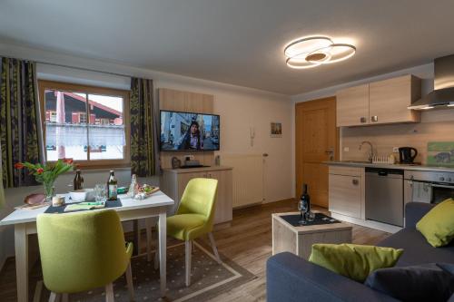 a kitchen and living room with a table and chairs at Haus Holzeck in Schönau am Königssee