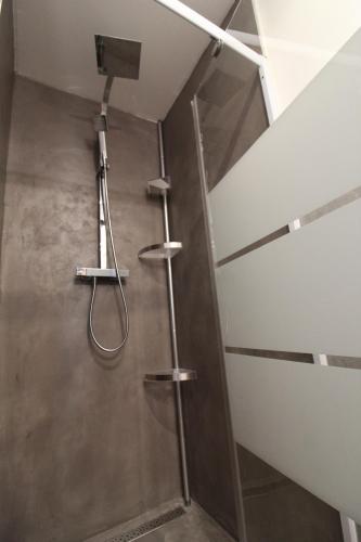 une douche dans une salle de bain avec une porte vitrée dans l'établissement Rogliano, à Porto-Vecchio