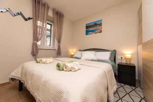 a bedroom with two beds with towels on them at Apartments Neptun in Baška