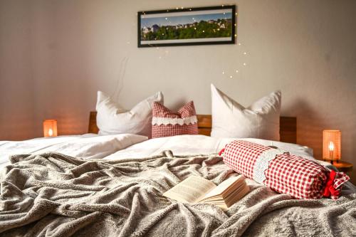 uma cama com dois livros e almofadas em Fewo Pöhlbergblick Wolkenstein em Wolkenstein