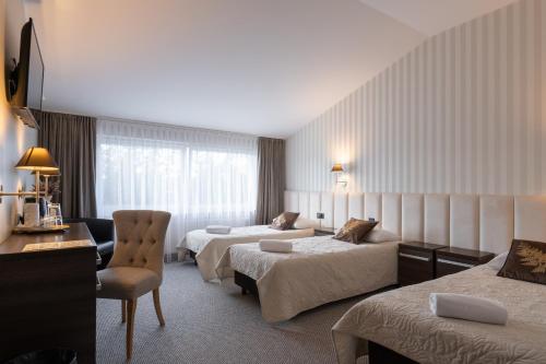 Pokój hotelowy z 2 łóżkami i krzesłem w obiekcie Złoty Staw w Gdańsku