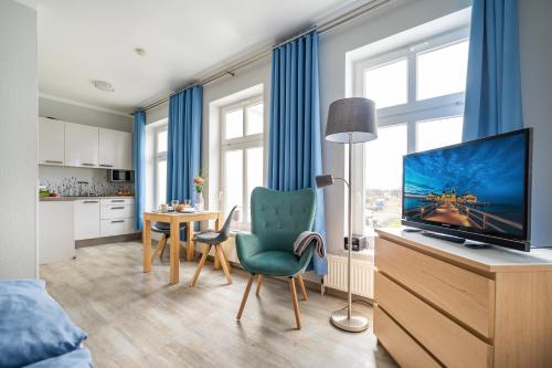 ein Wohnzimmer mit einem TV und einem Tisch mit Stühlen in der Unterkunft Haus Ferienglück Sauna im Haus in Ostseebad Sellin