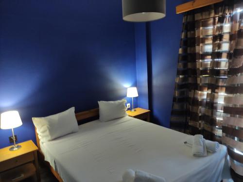 a bedroom with a large bed with two tables and two lamps at Pension Niki in Skála Sykaminéas