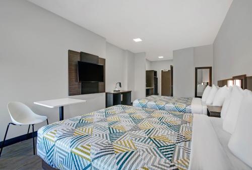 ein Hotelzimmer mit 2 Betten und einem Schreibtisch in der Unterkunft Motel 6-Monahans, TX in Monahans