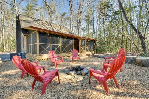 a group of red chairs in front of a cabin at Cozy Creekside Mountain Escape with Hot Tub! in Sautee Nacoochee