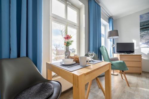 ein Esszimmer mit blauen Wänden sowie einem Tisch und Stühlen in der Unterkunft Haus Ferienglück Sauna im Haus in Ostseebad Sellin