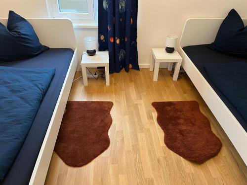 een kamer met 2 bedden en 2 tafels met tapijten bij Gemütliches Appartement am Völkerschlachtdenkmal in Leipzig