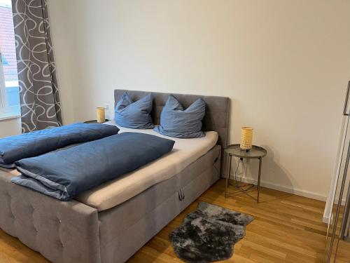 uma cama com almofadas azuis num quarto em Gemütliches Appartement am Völkerschlachtdenkmal em Leipzig