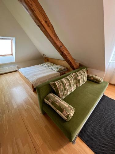 um quarto com uma cama e um sofá no sótão em Penzion Viktoria em Znojmo