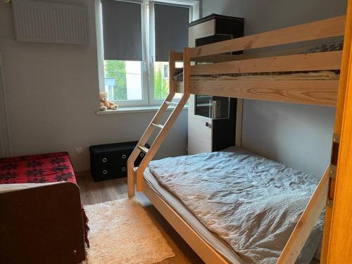 Un dormitorio con dos literas y una ventana. en Apartament/Mieszkanie, ścisłe centrum., en Częstochowa