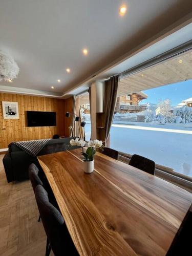 une salle à manger avec une longue table en bois et des chaises dans l'établissement Megeve centre, à Megève