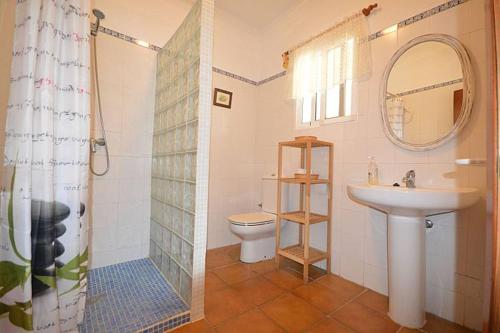 bagno con lavandino, servizi igienici e specchio di Casa Samuel Mayorazgo con piscina compartida a Cadice