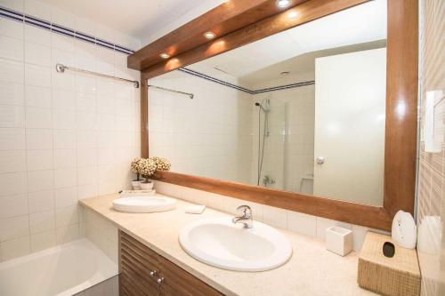 une salle de bain avec deux lavabos, un miroir et une baignoire dans l'établissement Apartamento Valerie, à Vilamoura