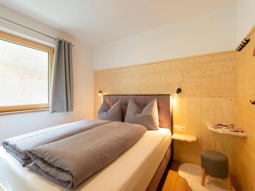 a bedroom with a large bed with a window at Haus Heimat - Alpenrose 