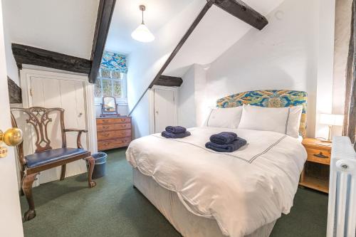 a bedroom with a large white bed and a chair at Thwaite Cottage Coniston in Coniston
